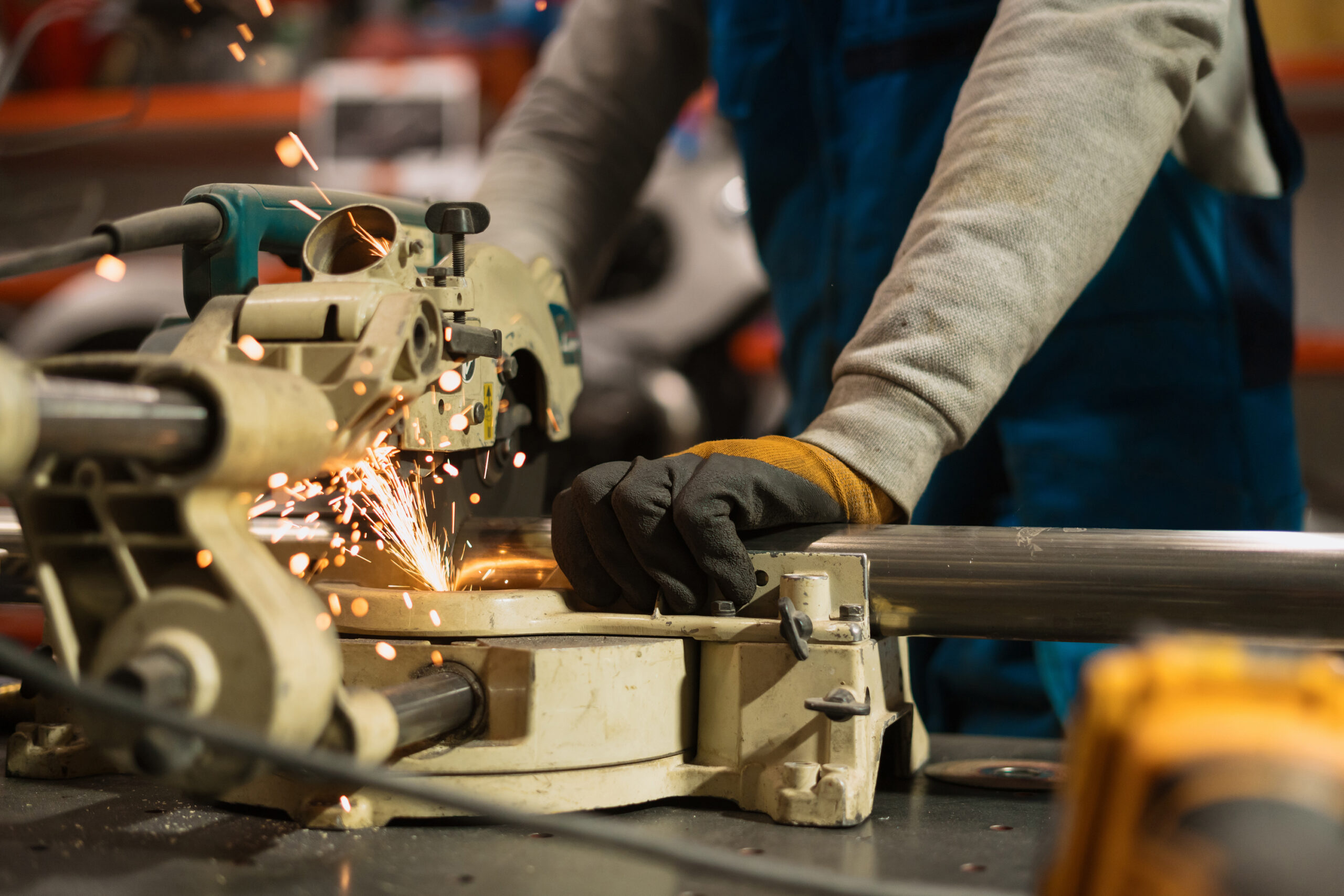 Technician worker cutting metal with many sharp sparks. Using equipments to cat iron